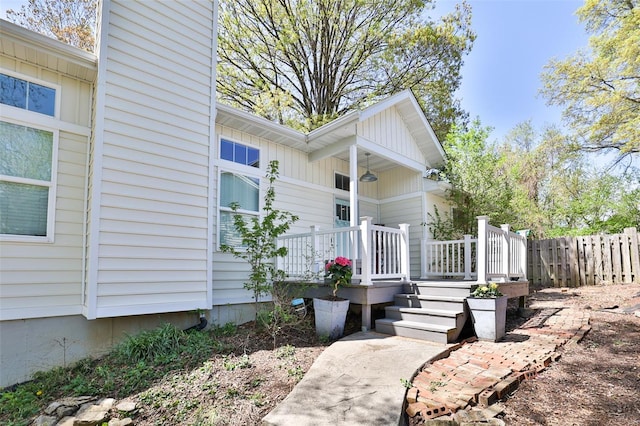 entrance to property with fence and board and batten siding
