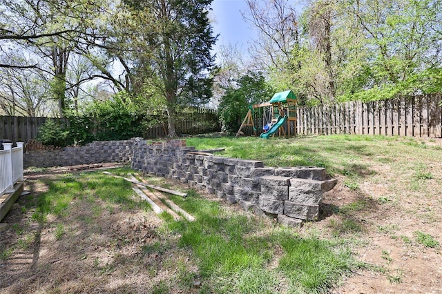 view of yard with a fenced backyard and a playground
