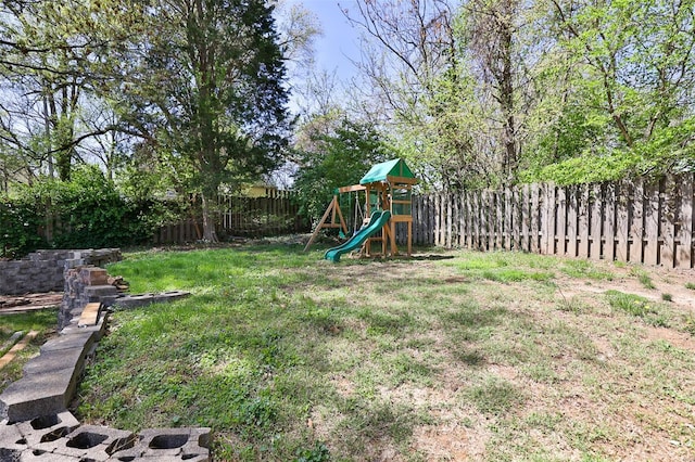 view of yard with a fenced backyard and a playground