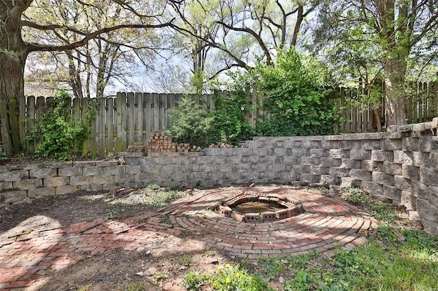 view of yard featuring a patio area, a fenced backyard, and an outdoor fire pit