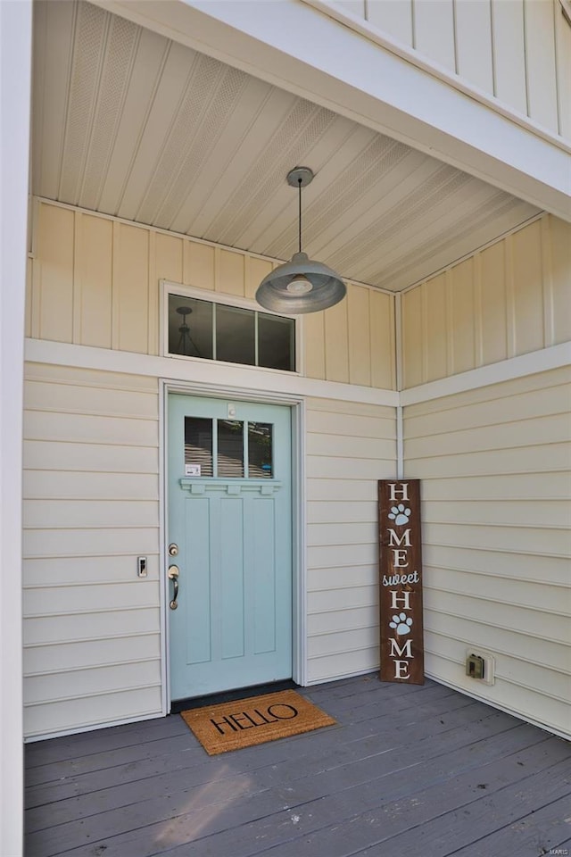 entrance to property featuring board and batten siding and ceiling fan