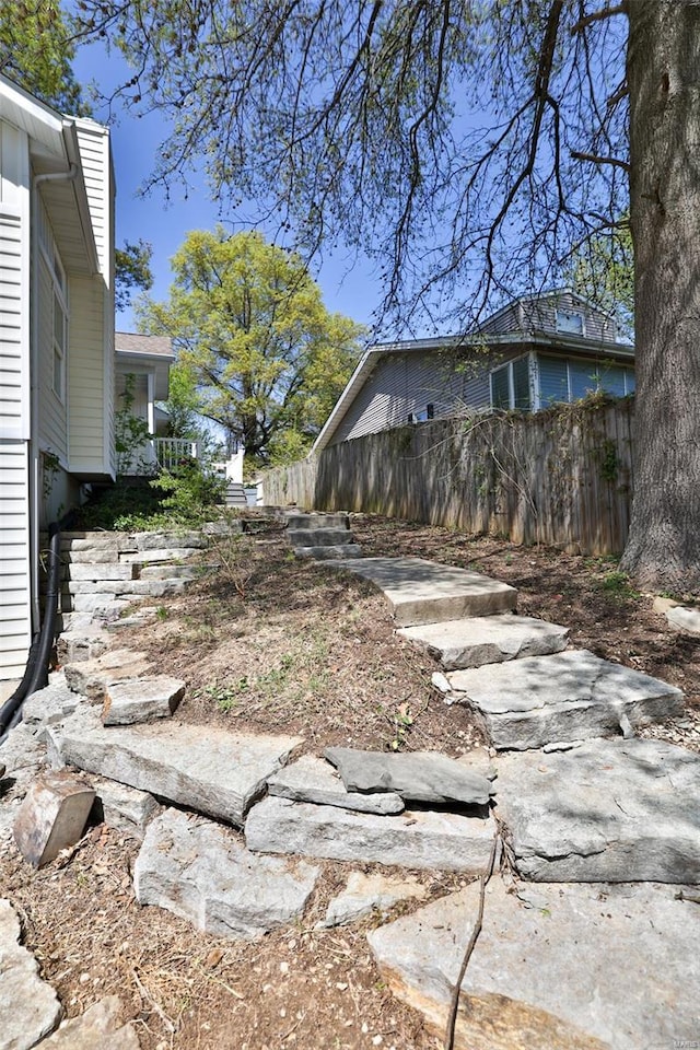 view of side of home featuring fence