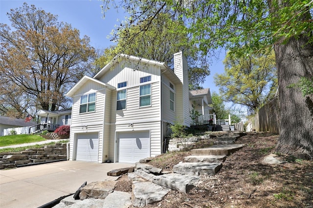 view of home's exterior with a chimney, board and batten siding, driveway, and a garage