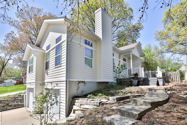 view of property exterior with a chimney and a garage