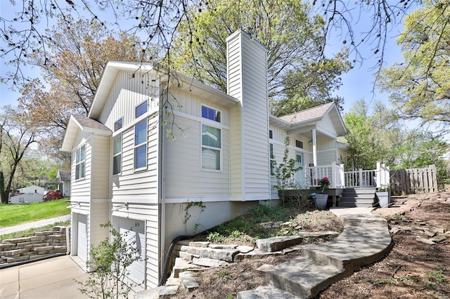 view of side of property featuring a chimney, board and batten siding, and a deck
