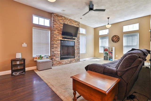 living room featuring ceiling fan, baseboards, a healthy amount of sunlight, and a fireplace