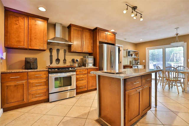 kitchen with brown cabinetry, stainless steel appliances, wall chimney exhaust hood, and light tile patterned flooring