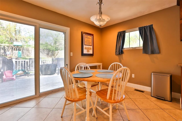 dining space with light tile patterned floors, visible vents, and baseboards