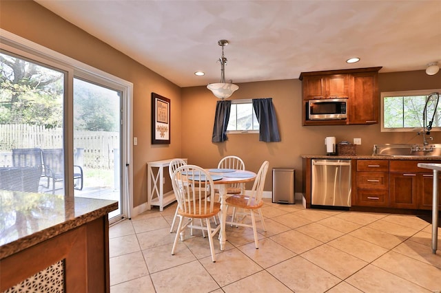 kitchen featuring appliances with stainless steel finishes, recessed lighting, brown cabinetry, and baseboards