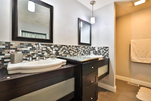 bathroom with tile patterned flooring, backsplash, vanity, baseboards, and visible vents