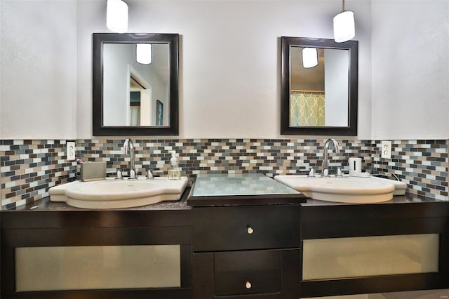 bathroom with tasteful backsplash, two vanities, and a sink