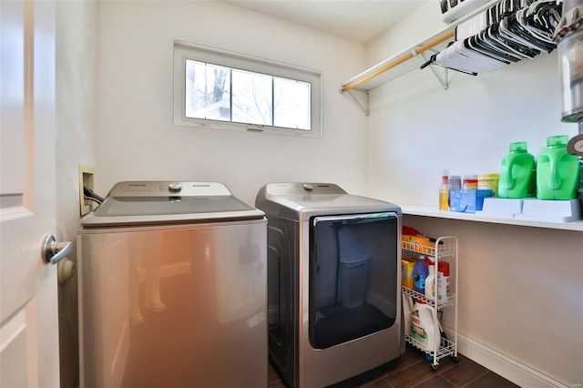 washroom with dark wood-style floors, baseboards, laundry area, and washer and clothes dryer