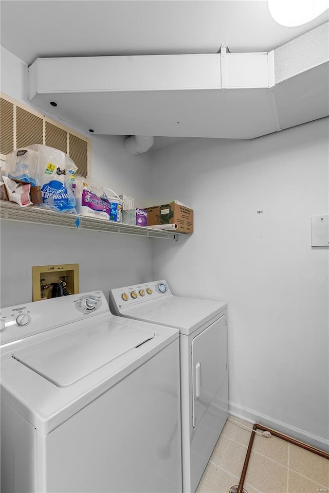 washroom with baseboards, washer and dryer, and laundry area