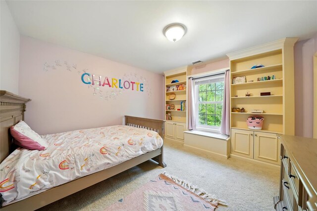 bedroom with visible vents and light carpet