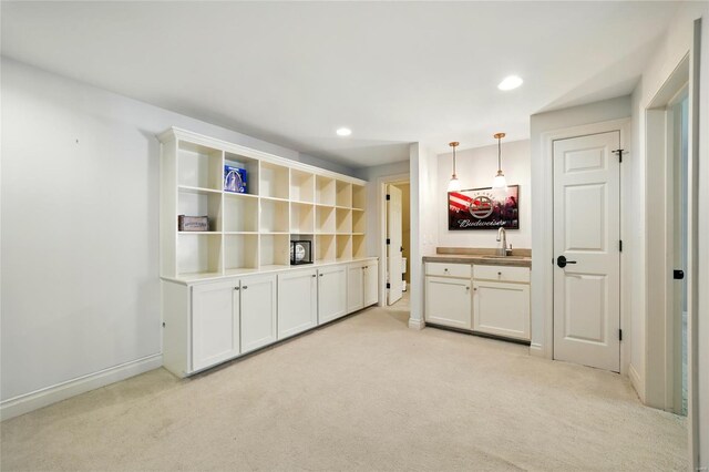 interior space featuring a sink, bar area, light carpet, decorative light fixtures, and recessed lighting