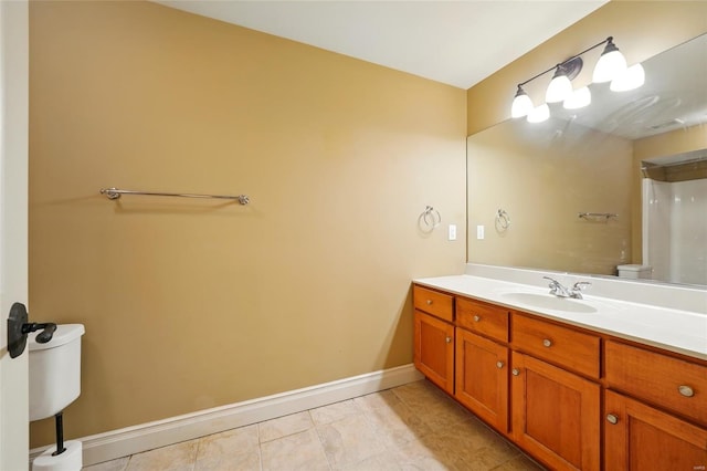 bathroom featuring tile patterned flooring, baseboards, toilet, and vanity
