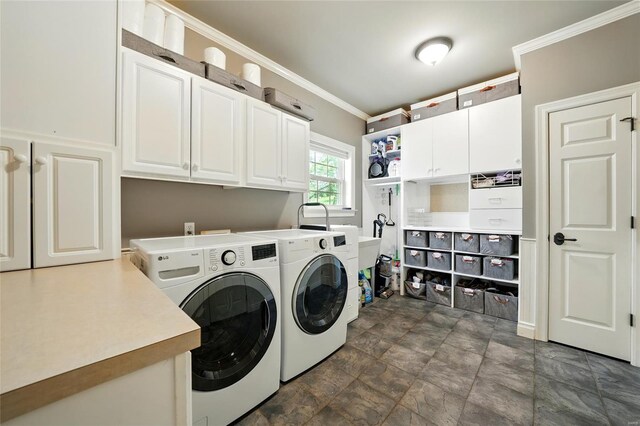 clothes washing area featuring ornamental molding, washing machine and clothes dryer, cabinet space, and stone finish floor