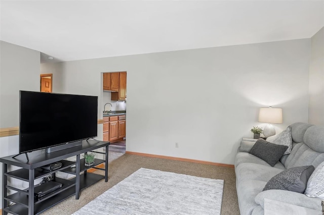 living area with baseboards and light carpet