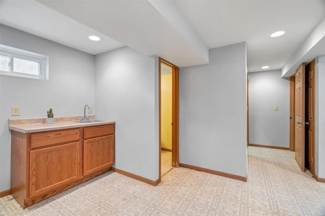 interior space featuring baseboards, a sink, and recessed lighting