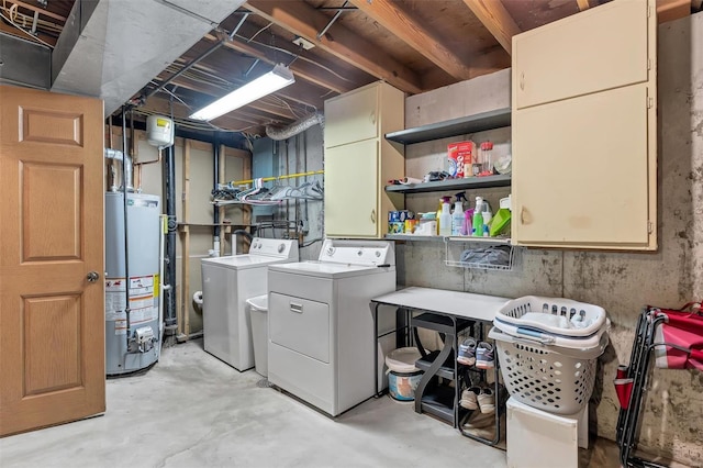 washroom featuring cabinet space, water heater, and washer and dryer