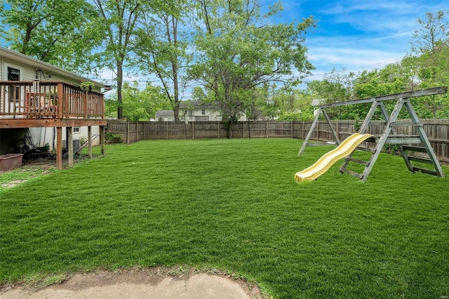 view of yard featuring a fenced backyard, a playground, and a deck