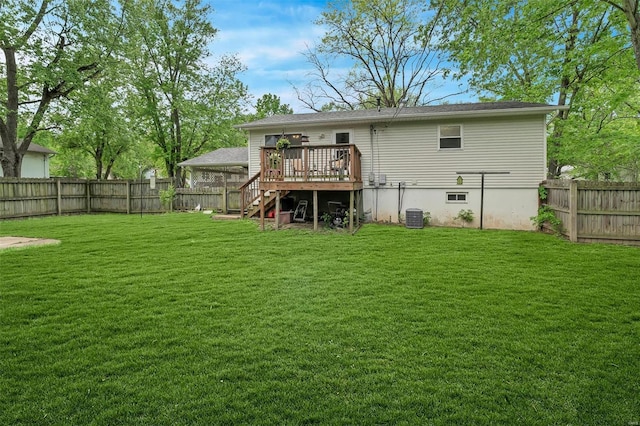 back of property featuring a lawn, a wooden deck, stairs, and a fenced backyard