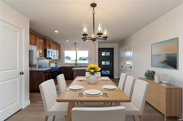 dining room featuring recessed lighting, a chandelier, and light wood-type flooring