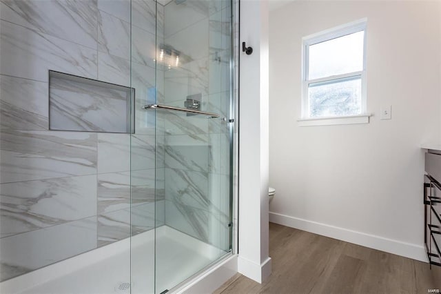 full bath with a shower stall, vanity, toilet, baseboards, and wood finished floors