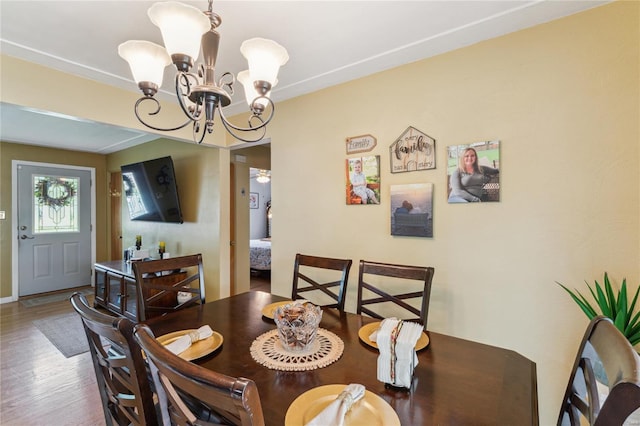 dining room with wood finished floors and an inviting chandelier