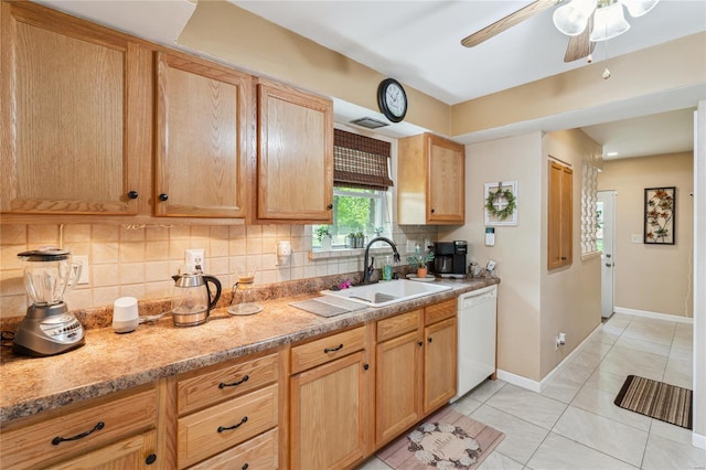 kitchen featuring a sink, decorative backsplash, light tile patterned floors, white dishwasher, and baseboards