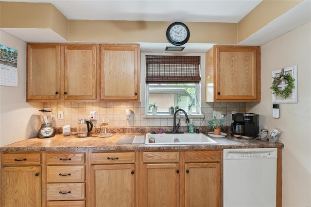 kitchen featuring a sink, light brown cabinets, backsplash, and white dishwasher