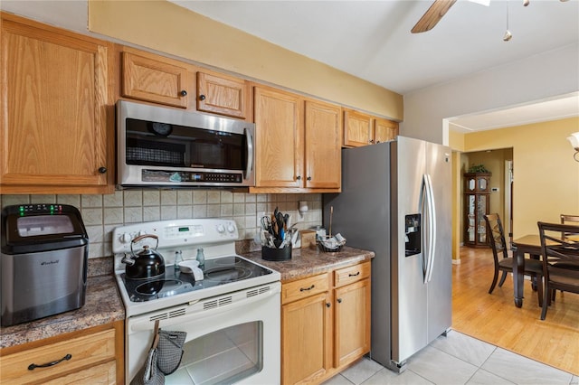 kitchen featuring light tile patterned floors, backsplash, appliances with stainless steel finishes, and ceiling fan