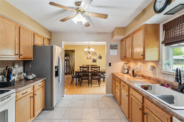 kitchen with decorative backsplash, a sink, visible vents, ceiling fan with notable chandelier, and stainless steel fridge with ice dispenser