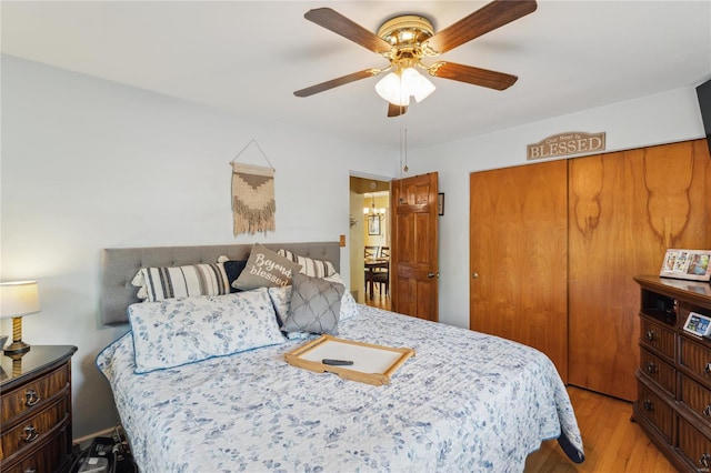 bedroom with ceiling fan, light wood-style flooring, and a closet