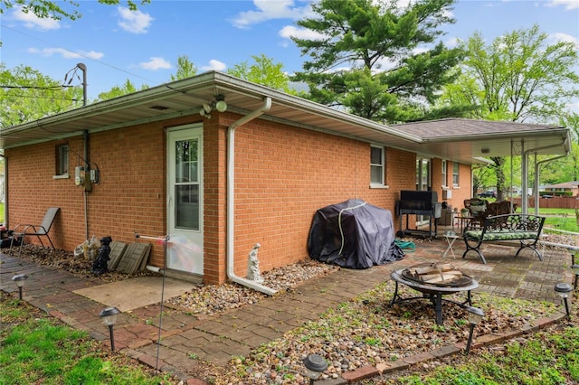 back of property featuring an outdoor fire pit, a patio, and brick siding