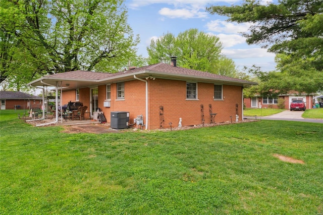 rear view of property featuring a patio, brick siding, cooling unit, and a lawn