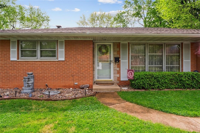 single story home featuring brick siding and a front lawn
