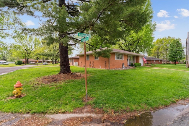 view of side of property with a yard and brick siding