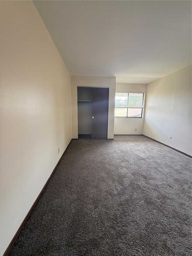 empty room with baseboards and carpet
