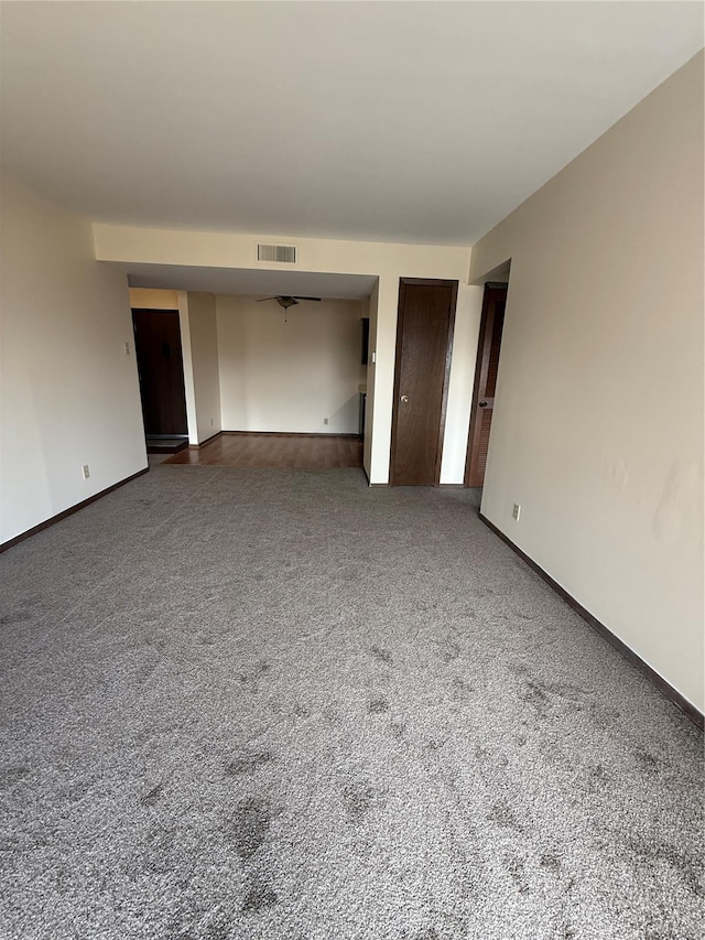 carpeted spare room with baseboards and visible vents
