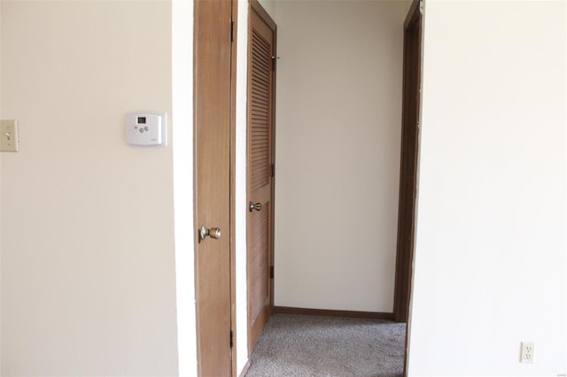 corridor with carpet floors and baseboards