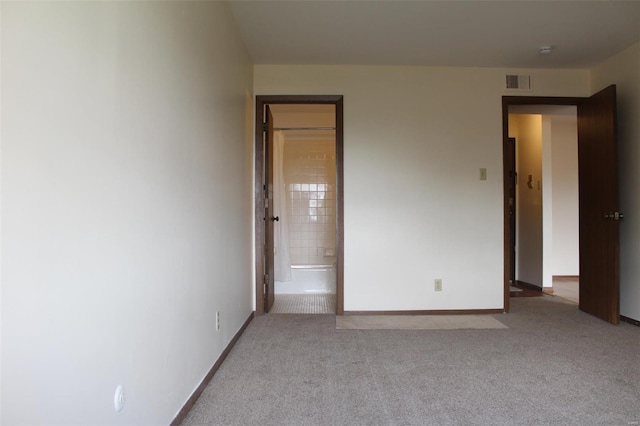 unfurnished bedroom with baseboards, carpet flooring, ensuite bath, and visible vents