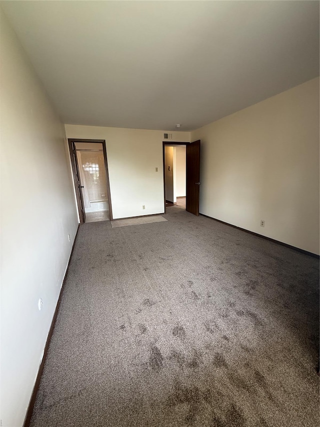 carpeted spare room featuring baseboards