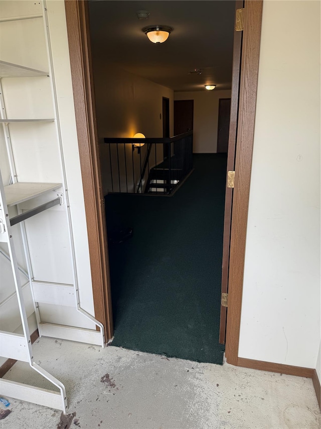 hall with baseboards and an upstairs landing