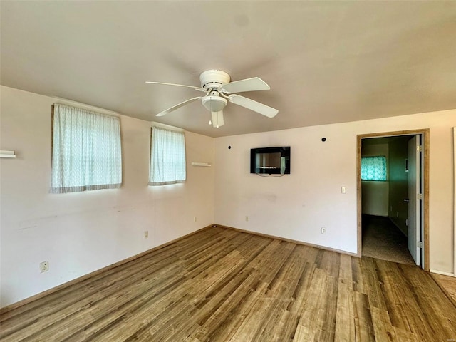 unfurnished room featuring baseboards, a ceiling fan, and wood finished floors