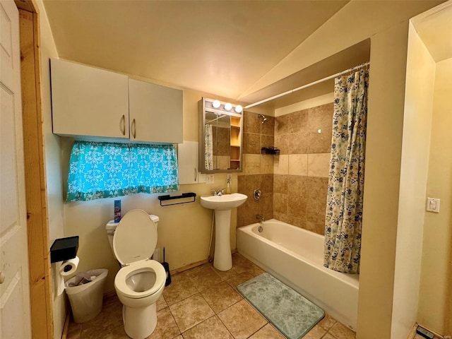 bathroom with tile patterned floors, a sink, toilet, lofted ceiling, and shower / bath combo with shower curtain
