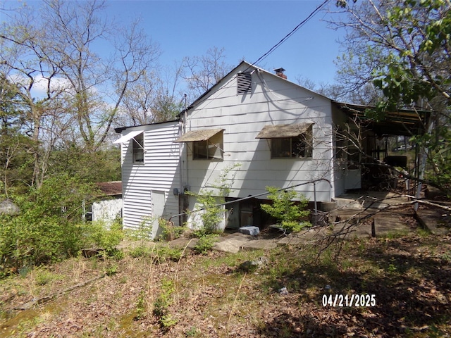 rear view of property featuring a chimney