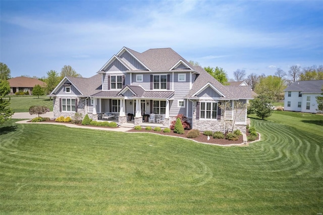 craftsman-style home featuring a porch, stone siding, a standing seam roof, and metal roof