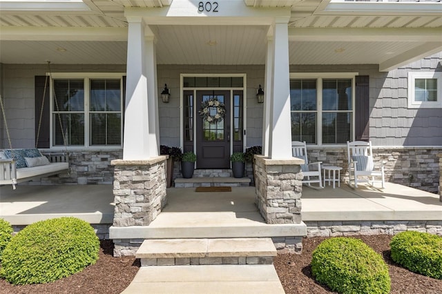 property entrance with stone siding and covered porch