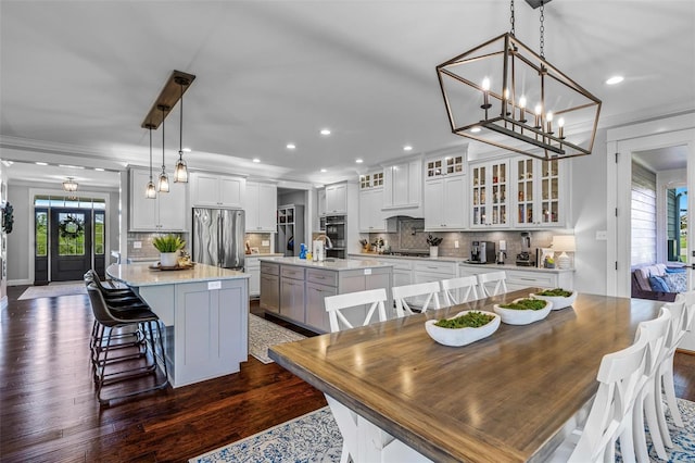 dining area with crown molding, recessed lighting, and dark wood finished floors